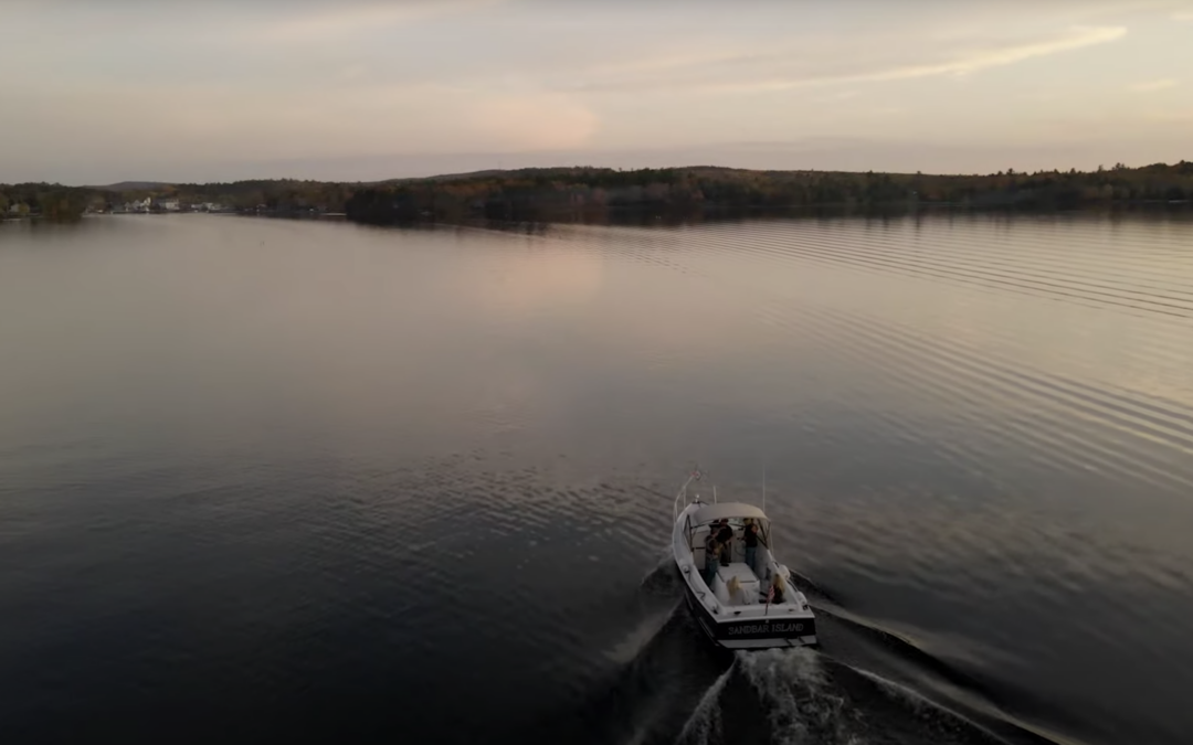 Boat driving across the water on a lake during sunset