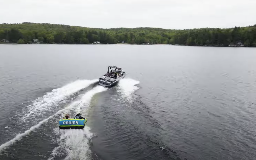 Raft being dragged across water by a boat on a lake