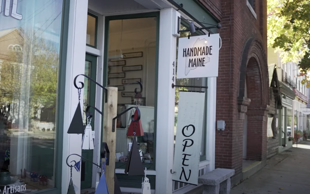 A downtown city street with a sign that says "Handmade Maine"