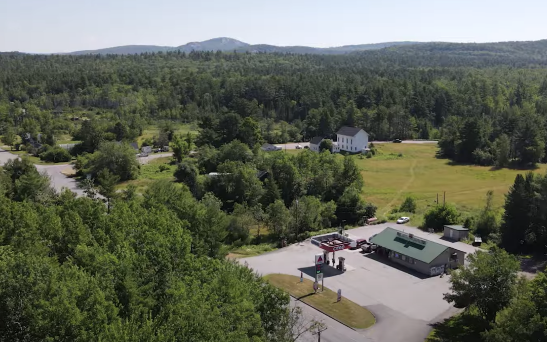 Arial view of mountains, trees, and a general store with gas pump